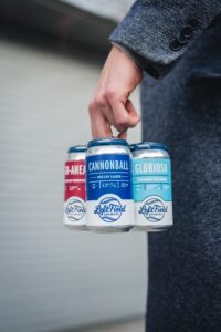 Person Holding Beer Cans - National Beer Can Appreciation Day
