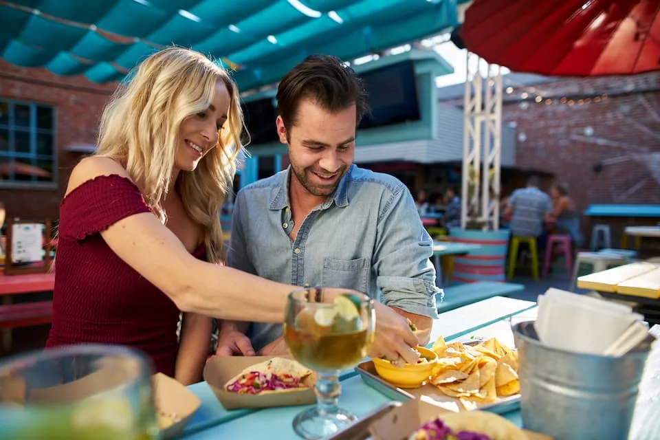 Couple is eating one of the popular street food tacos and nachos - Chef's Deal