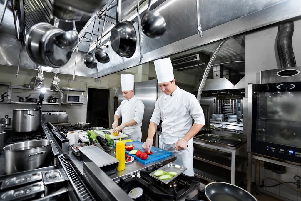 2 Chef's are preparing food in a well desgined kitchen - Why Commercial Kitchen Equipment Layout Matters - Chef's Deal