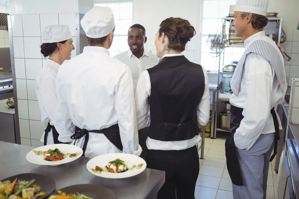 Training staff on equipment prevent possible damages and extend the lifespan of commercial kitchen equipment. Restaurant staff are on equipment training in a kitchen.
