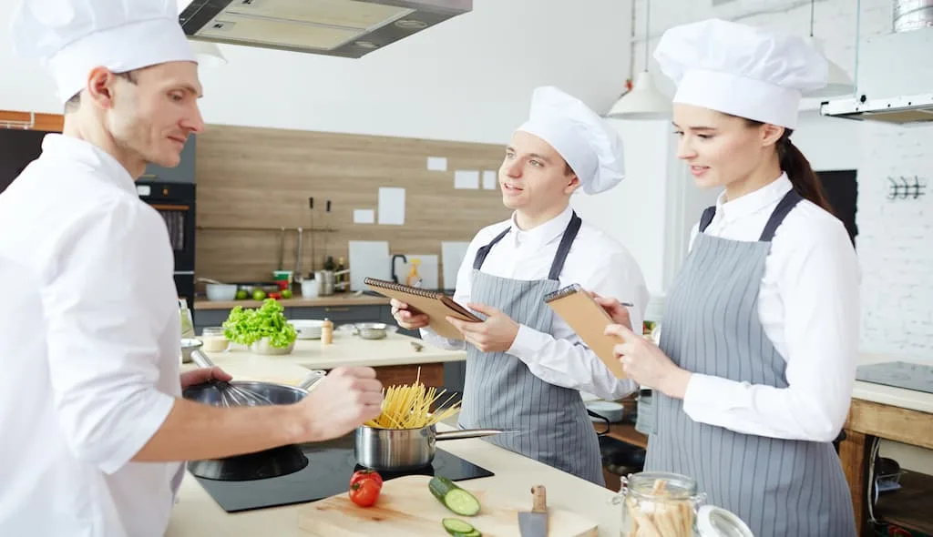 3 chefs are creating menu at a restaurant kitchen