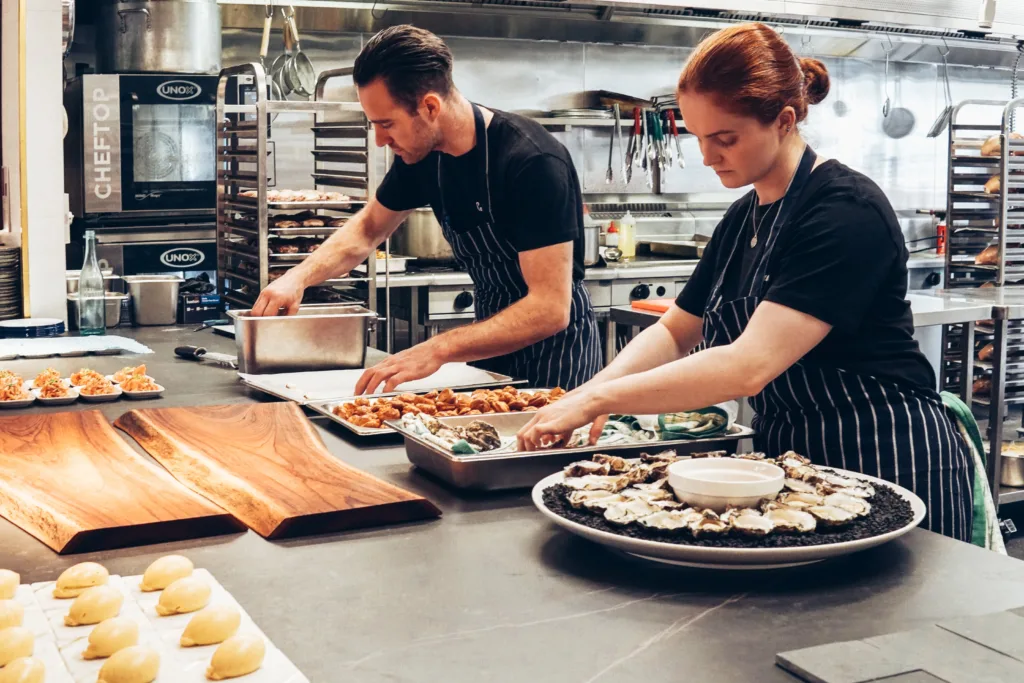 2 chefs are preparing dishes in a restaurant kitchen - History and Evolution of Commercial Kitchen Equipment